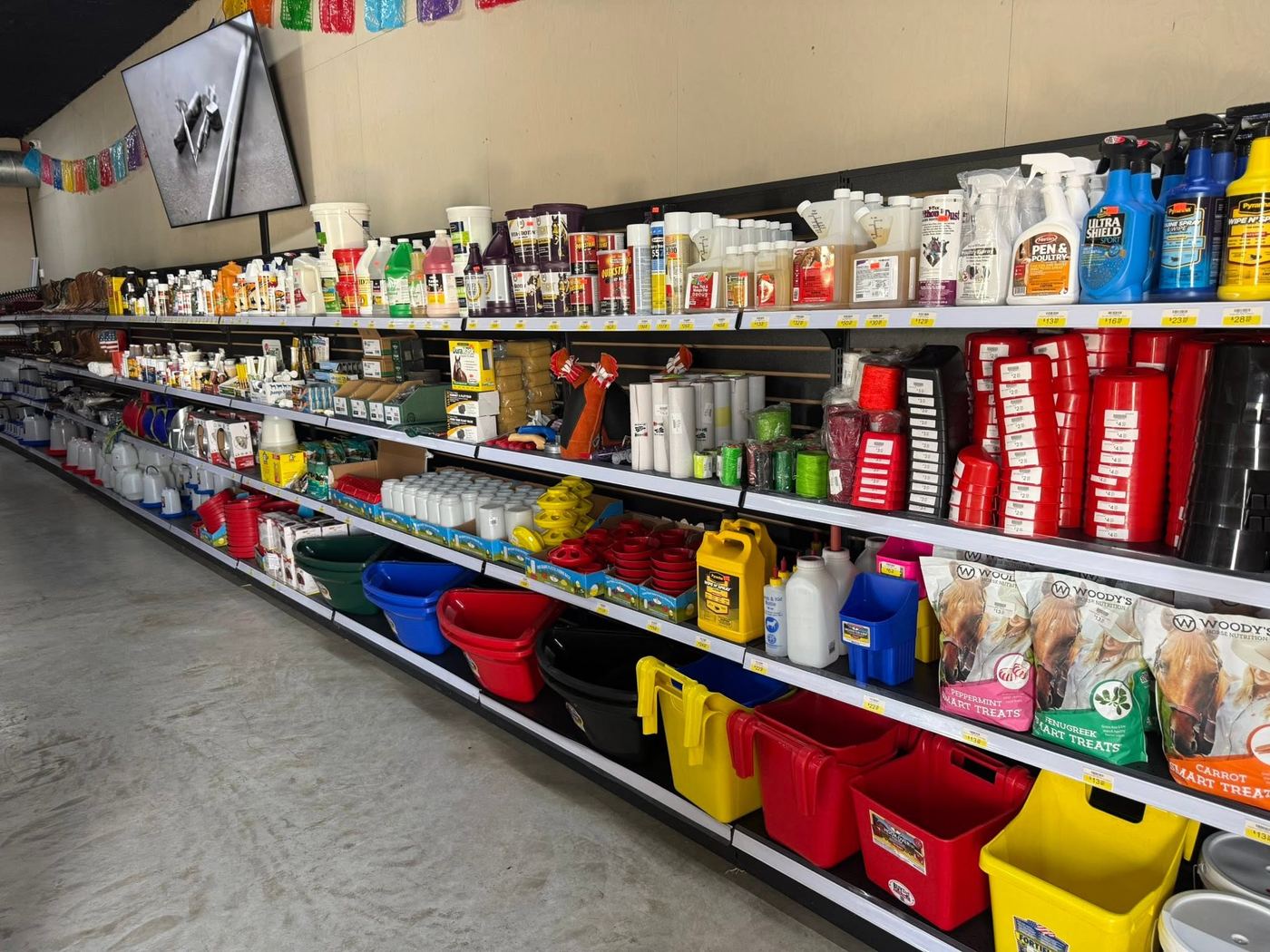 Store aisle with fly spray, buckets, feeders and waterers