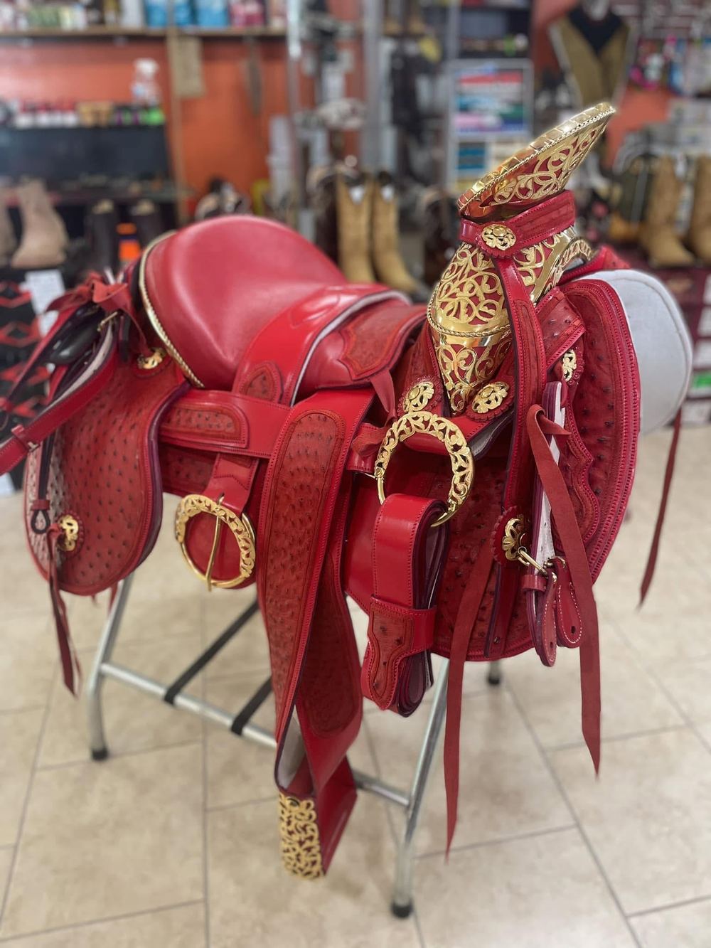Red ostrich-leather charro saddle with gold filigree hardware